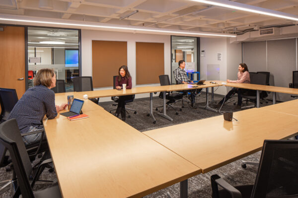 People sitting around large conference tables in a meeting room